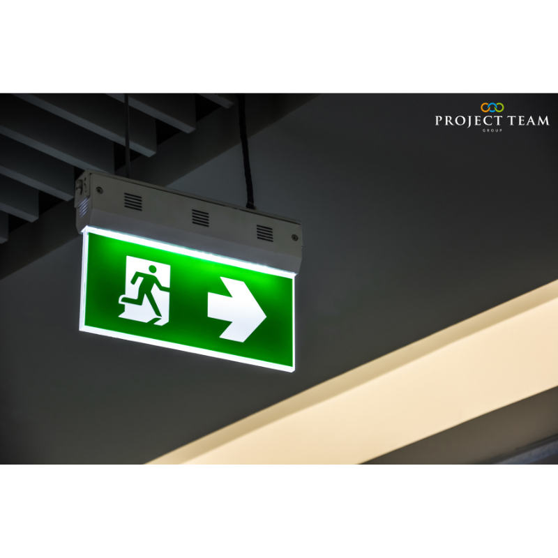 Illuminated green emergency exit sign hanging on ceiling in mode